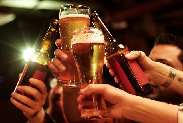 друзья чокаются бокалами чешского пива в пражском пабе вечером